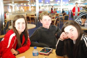 Kiefer High School sophomore Savannah Lee, senior Ashton Cooprider and freshman Sierra Lee play games in one of the lounge areas of the ferry while crossing the Irish Sea to Wales.