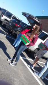 Kiefer Junior High 8th grader Lyndsey Bills loads boxes for Operation Christmas Child into the back of her class sponsor's car.