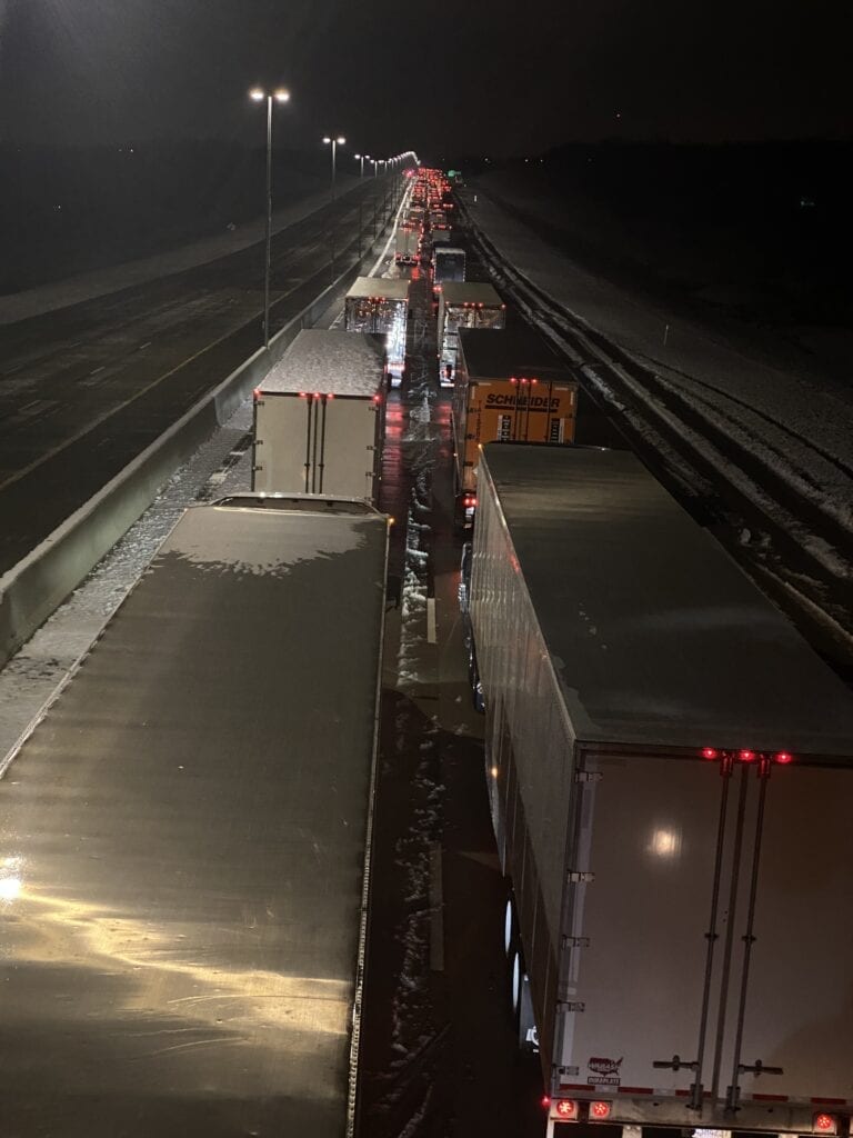 Semi trucks traveling westbound on the Turner Turnpike at a standstill due to a downed power line. Micah Choquette photo.