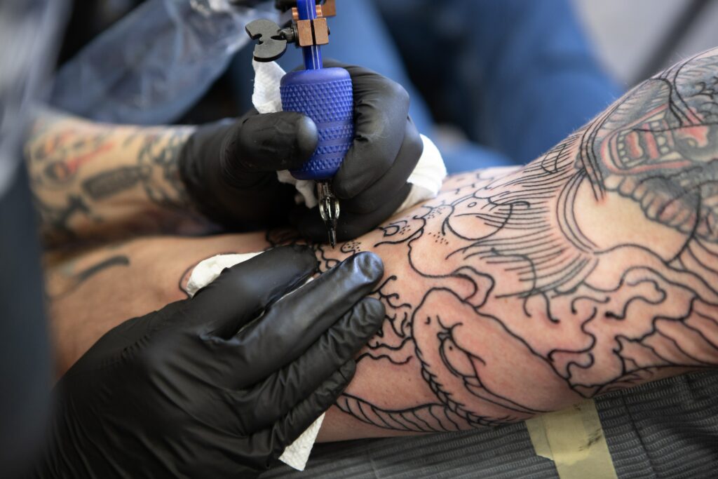 A young man gets a tattoo cover-up.